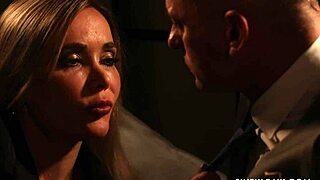 Pornstar gives blowjob while bent over in lingerie.