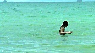 The girl in a sexy bikini poses near the crocodile