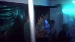 an amateur brunette coed teases and sucks a hard cock at a university party, watched by voyeurs in a group setting.