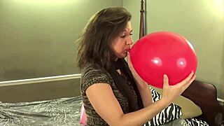 Bubblegum chews by brunette looner while popping balloons
