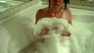 The tiny red slut with a perfect body teases in the bathtub, fingering herself.
