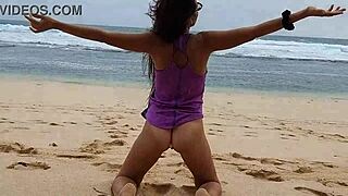 i'm doing yoga on the wild beach with my pink butt plug, no panties on, naked and close-up