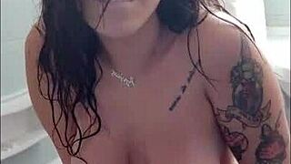 tattooed brunette masturbates with dildo in bathtub