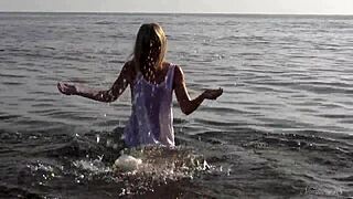 Model poses nude in the ocean, sensual blonde