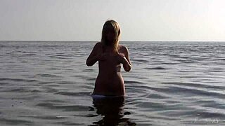 Model poses nude in the ocean, sensual blonde