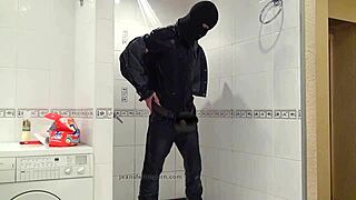 A gay man is washing in a bathtub and is clad in blue jeans