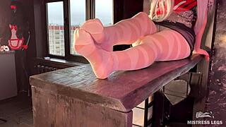 Foot freaks get closer as a woman in white pantyhose uncrosses her legs placing her feet on a table and wiggling her toes