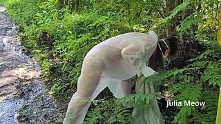 A naked girl is picking up litter near the road, flashing her shaved pussy