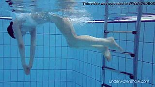 roxalana cheh, the sexy redhead, stuns while swimming underwater in a public spot.