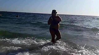 this horny milf is masturbating her wet pussy on the beach, showing off her big tits and fat ass while feeling so aroused outside