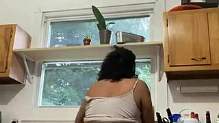 A Latina milf enjoys washing dishes in the kitchen.