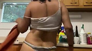 A Latina milf enjoys washing dishes in the kitchen.