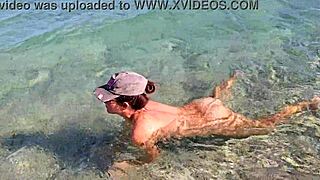 nudist girl enjoys freedom at a public beach. voyeur captures her natural beauty in the sun.