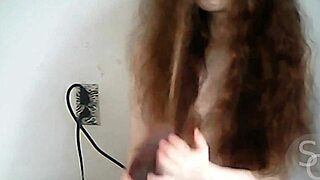 Topless teen pornstar exposes natural tits and pussy on cam in outdoor public setting.