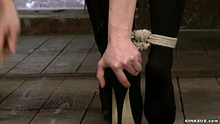 Why is the big tits slave tied and caned with a dildo?