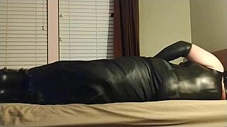this crossdresser ties himself up in leather boots, gagging and choking on his own ass