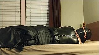 this crossdresser ties himself up in leather boots, gagging and choking on his own ass