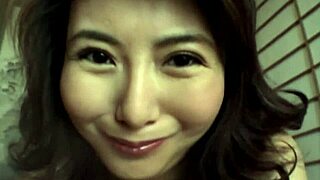 Japanese woman with natural tits performs handjob closeup.