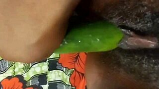 Close up of a webcam showing an amateur BDSM scene with a cucumber and a squirt