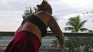 Girl flashing ass on balcony in skirt