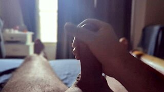 Intensely masturbating a massive cock in the bedroom with sunlight streaming through.