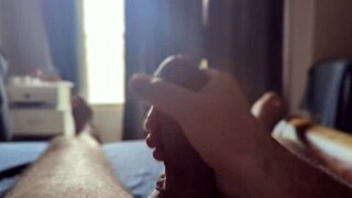 Intensely masturbating a massive cock in the bedroom with sunlight streaming through.