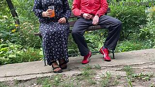 hot milf jerks off big dick into glass on park bench