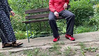 hot milf jerks off big dick into glass on park bench