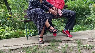 This hot milf casually strokes a huge cock into a glass while sitting on a park bench