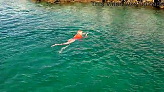 a skinny girl flashes her wet shaved pussy in blue water