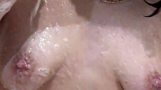Beautiful naked girl Assol masturbates in bath with soapy foam on pussy, boobs, ass, and feet.