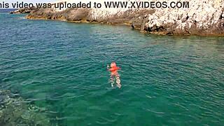 a skinny girl flashes her wet shaved pussy in blue water