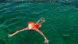 a skinny girl flashes her wet shaved pussy in blue water