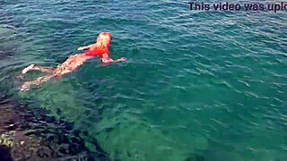 a skinny girl flashes her wet shaved pussy in blue water