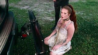 Submissive woman crawls from lagoon in humiliation scene.