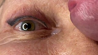 Mature cougar milf milks young stud's monster cock with handjob then takes huge facial cumshot on eyes and face