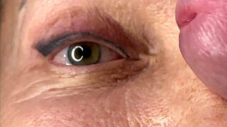 Mature cougar milf milks young stud's monster cock with handjob then takes huge facial cumshot on eyes and face