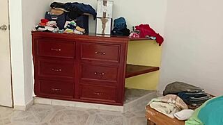 Chubby amateur folds clothes while tidying her messy room.