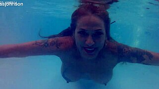 Melissa lounges as tattooed milf mermaid by pool with brown eyes