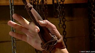 Bound lesbian slave gags on deepthroat buttplug while whipped in lezdom domination